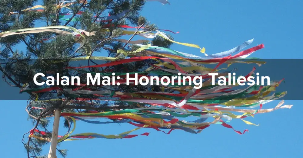 Brightly colored ribbons stream from a small pine tree against a clear blue sky. The words "Calan Mai: Honoring Taliesin" are superimposed.