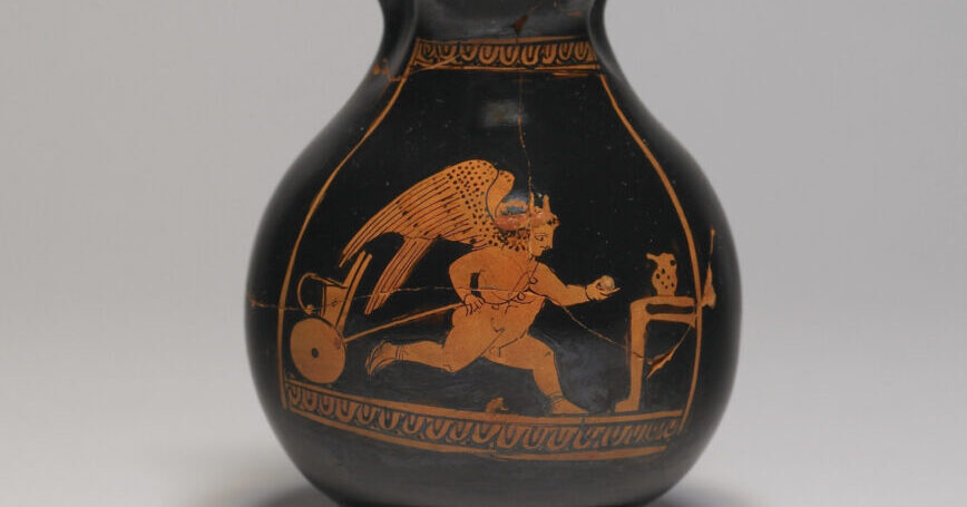 A black vase depicting, in red, a chubby Eros running and pulling a child's toy cart behind him