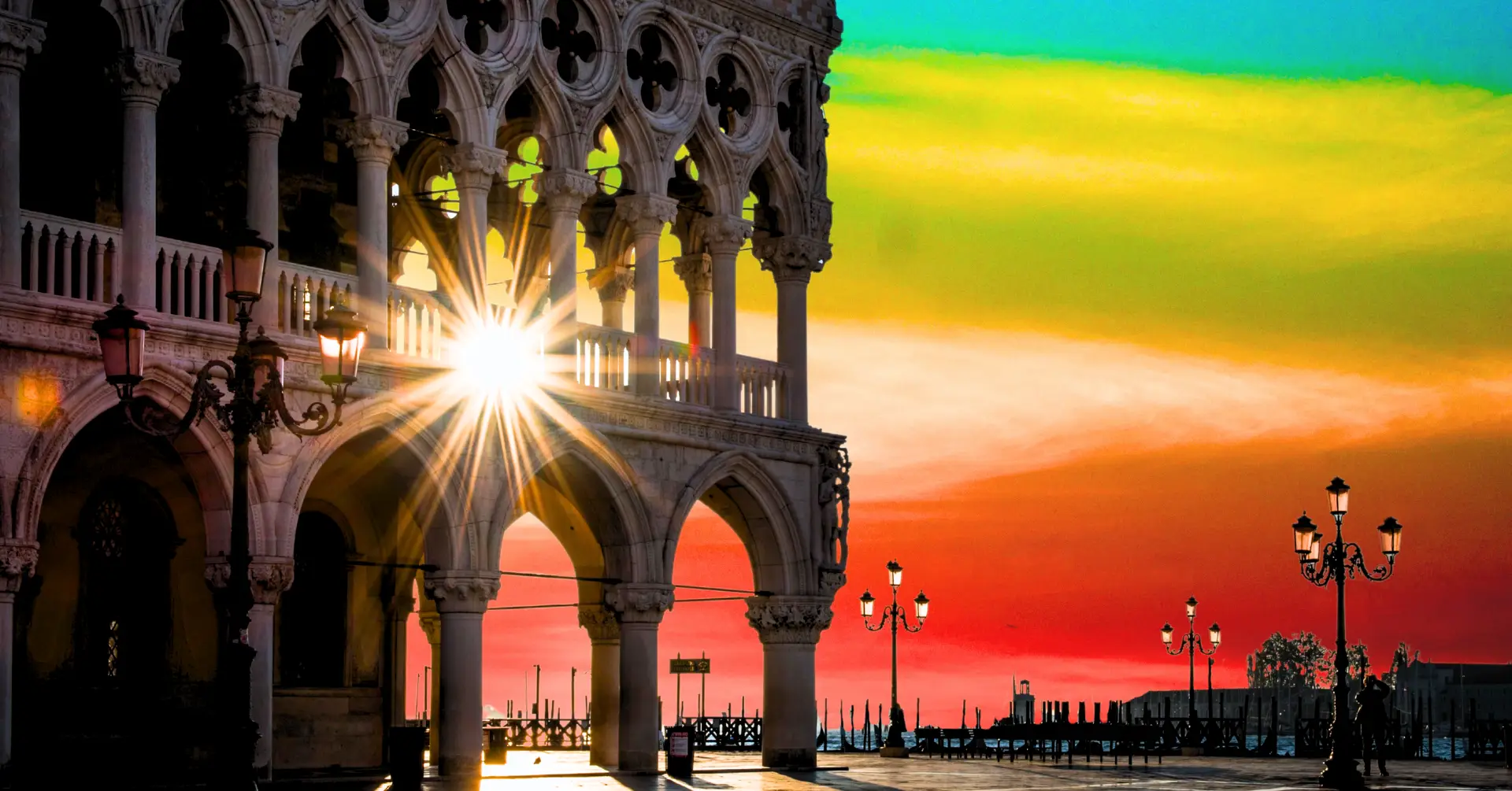 The sun gleams brightly through an ornate stone arcade, and the sky glows in brilliant rainbow colors behind